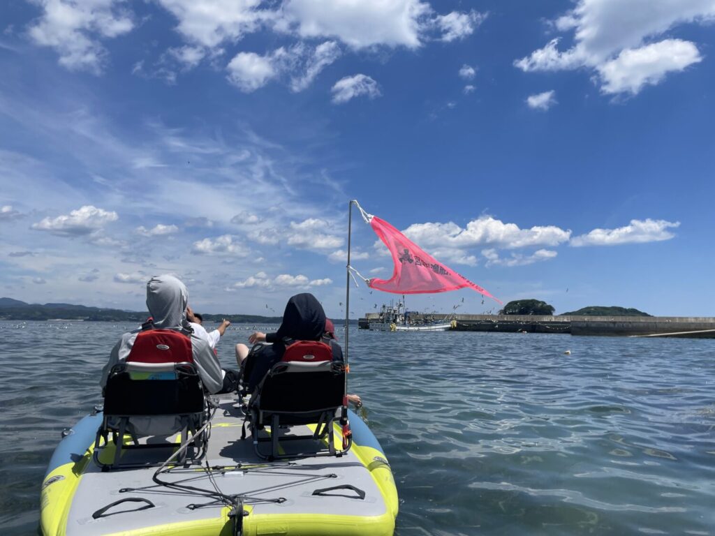 Adventurous kayakers navigating the sparkling ocean, aiming for a scenic island visible in the distance