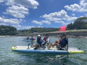 A group of participants having fun effortlessly gliding across the calm waters of Shizugawa Bay on hands-free Hobie pedal kayaks