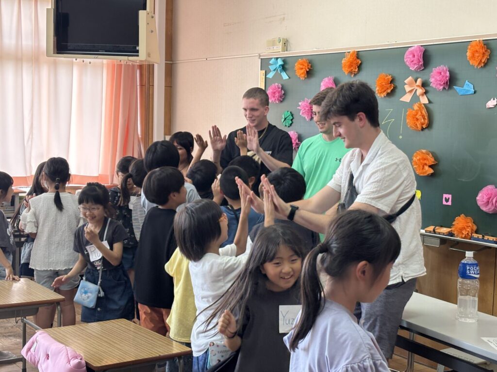 Participants interacting with local students in the classroom