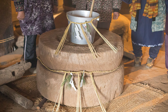 An inverted wooden mortar and fresh "young water" prepared for the sacred New Year farming ritual