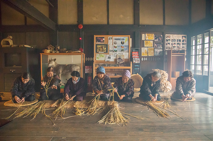Farmers twisting straw ropes on the earthen floor early in the morning as the first work of the New Year
