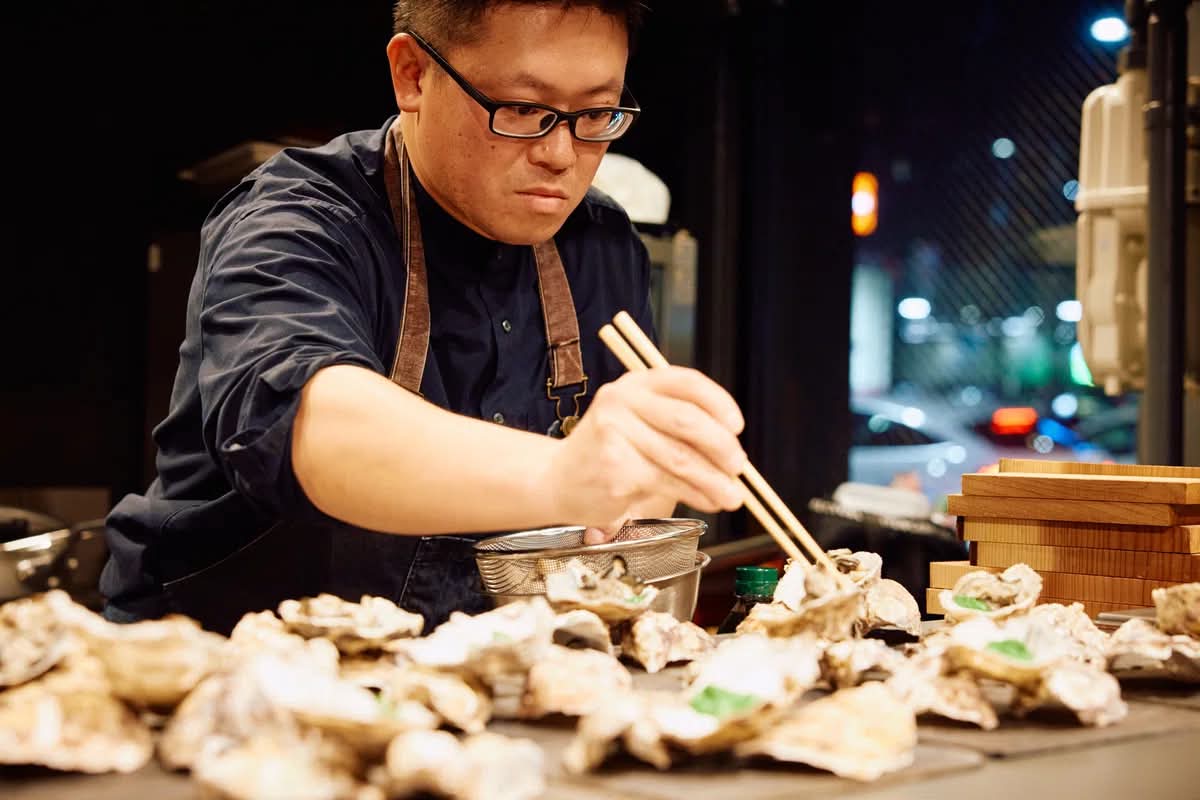 Professional Japanese chef and local fisherman preparing fresh seafood