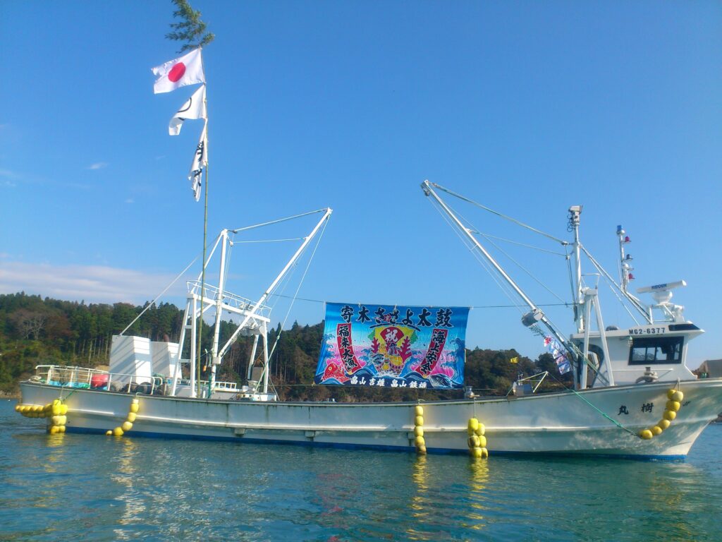 Local fishing boats decorated with vibrant colorful Tairyo-bata (good catch flags) at the harbor