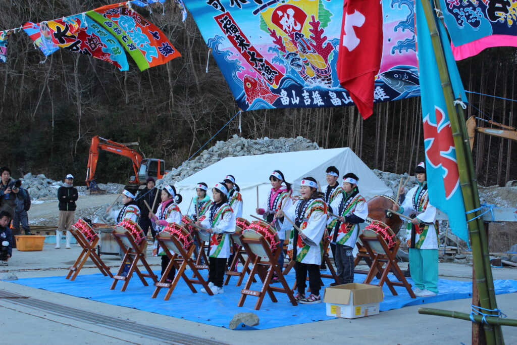Energetic performance of traditional Japanese drums (Taiko) by the bustling fishing port