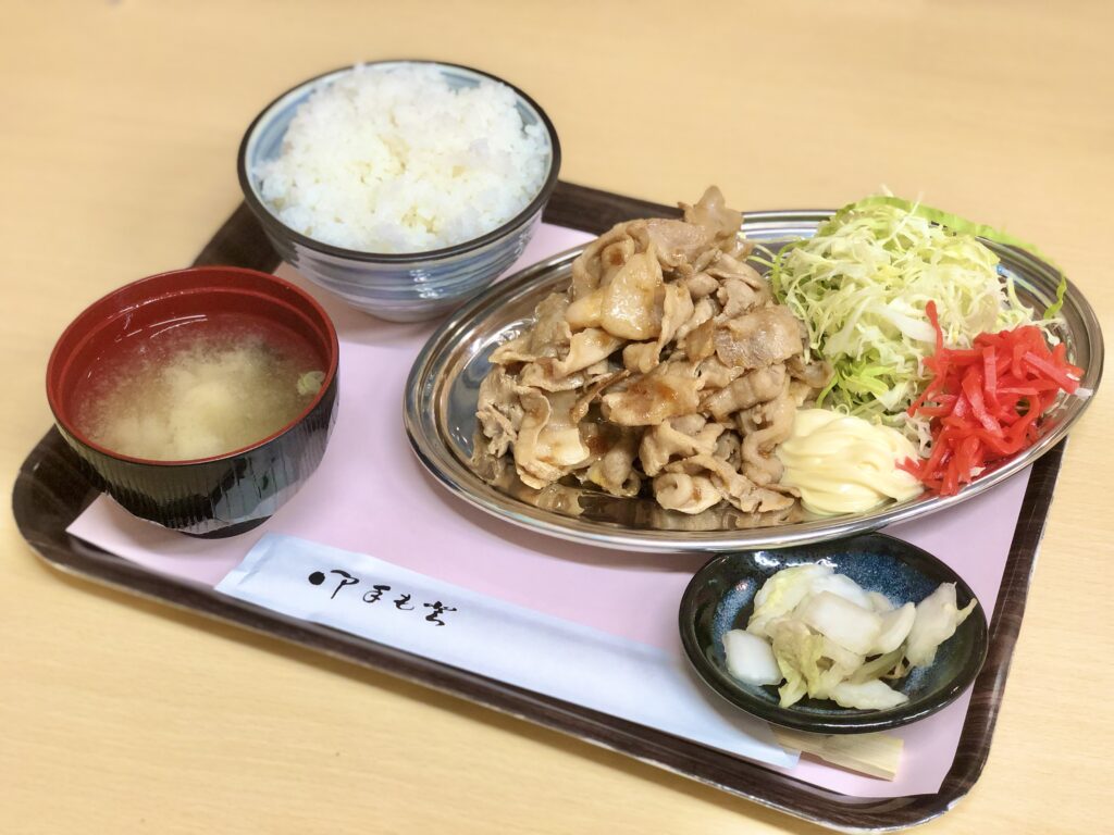 Hearty set meal including rice, miso soup, meat dishes, and fresh salad