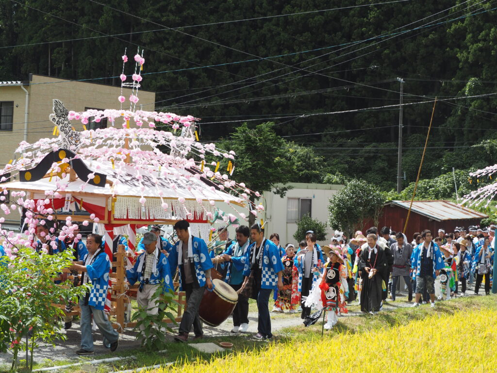 Festive procession and traditional dance celebrating the local harvest at a historic shrine