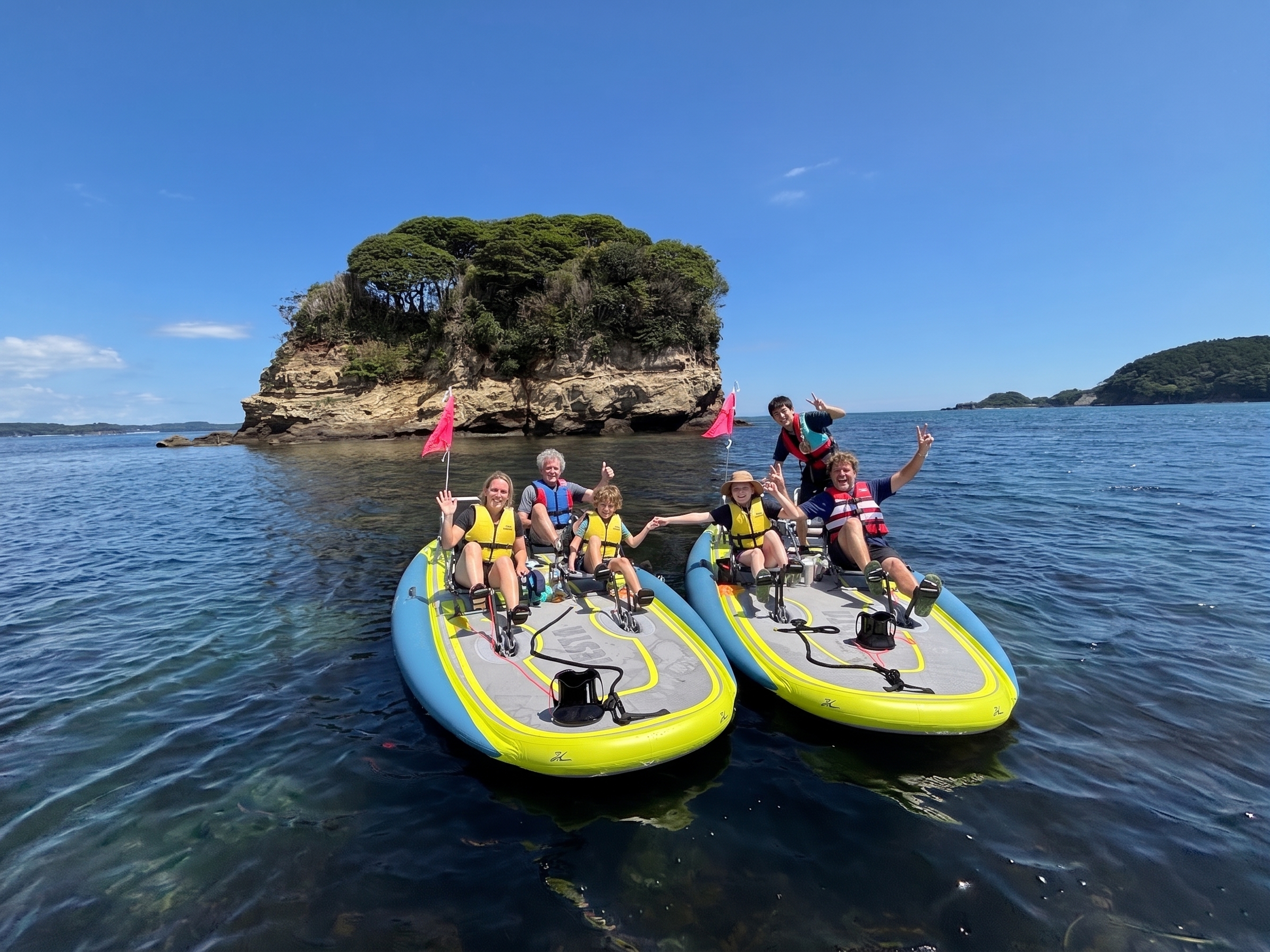 Two families enjoying a Hobie kayak adventure in the calm waters of Shizugawa Bay