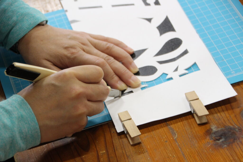 Delicate hand-cutting of traditional Kiriko paper patterns