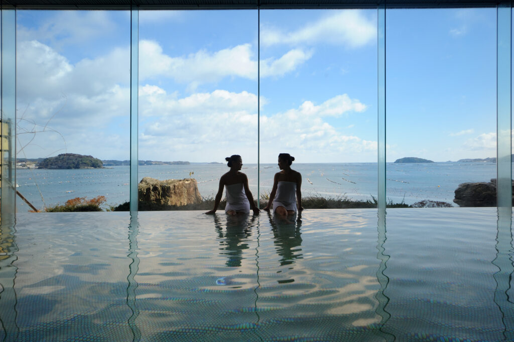 Relaxing in the large public bath at Hotel Kanyo while enjoying a spectacular panoramic ocean view