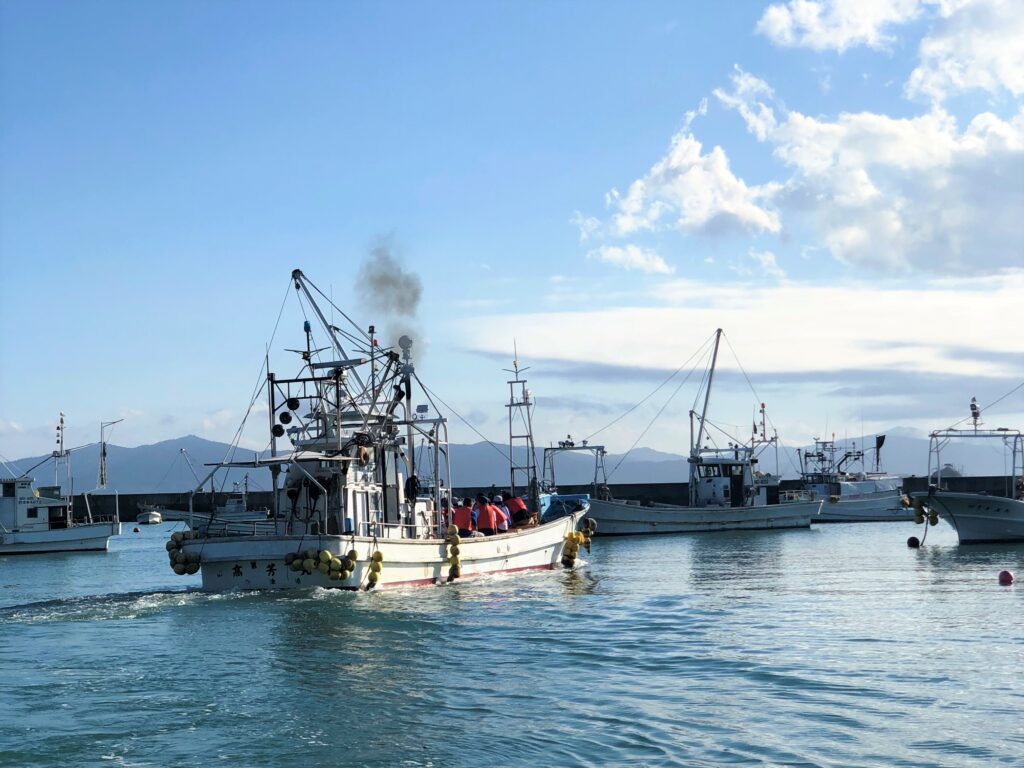 A local fishing boat carrying tour participants departing from the harbor for the Fisher's Cruise
