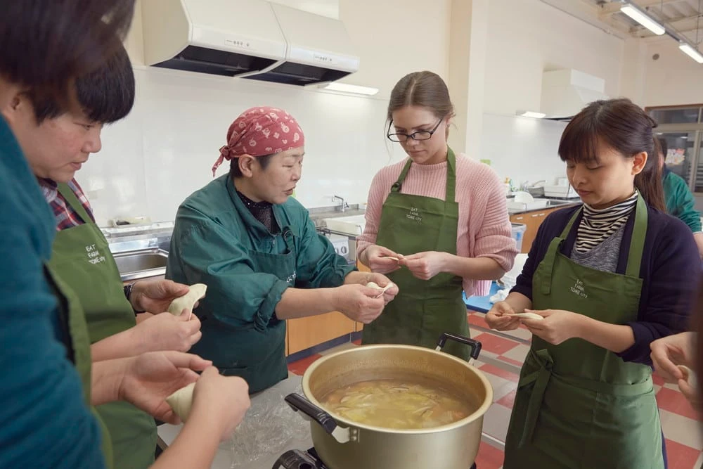 Visitors enjoying a hands-on cooking experience to learn how to make delicious traditional local cuisine